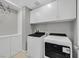 Laundry room with white cabinets and modern washer/dryer set at 3494 Brezine Ave, Henderson, NV 89044