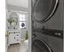 Bright bathroom features a modern vanity and mirror paired with a convenient stacked washer and dryer unit at 656 Tam O Shanter, Las Vegas, NV 89109