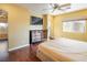 Main bedroom with large TV, ceiling fan and hardwood floors at 7491 Speedwell Cavern St, Las Vegas, NV 89139