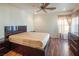 Bedroom with dark wood platform bed and ceiling fan at 7491 Speedwell Cavern St, Las Vegas, NV 89139