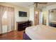 Spacious bedroom with wood floors and large TV at 7491 Speedwell Cavern St, Las Vegas, NV 89139