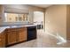 Bright kitchen features wood cabinets, tile floors, and a view into the dining area at 7491 Speedwell Cavern St, Las Vegas, NV 89139