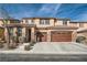 Two-story house with brown garage doors and landscaping at 7700 Tierra Montanosa Ave, Las Vegas, NV 89179