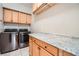 Laundry room with granite countertop, cabinets and newer appliances at 7700 Tierra Montanosa Ave, Las Vegas, NV 89179