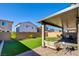 Relaxing backyard with covered patio, artificial turf, and seating area at 859 Benning St, Henderson, NV 89011