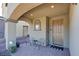 Inviting front porch with arched entryway, two chairs, and a welcome mat at 859 Benning St, Henderson, NV 89011