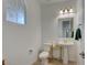 Modern powder room with pedestal sink, toilet, and decorative accents at 859 Benning St, Henderson, NV 89011