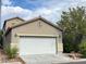 Two-story house with white garage door and desert landscaping at 8970 College Green St, Las Vegas, NV 89148