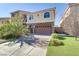 Two-story house with a brown garage door and landscaped front yard at 9635 Stoney Mesa Ct, Las Vegas, NV 89139