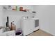 Bright laundry room with washer, dryer, and ample shelving at 1909 Pinsky Ln, North Las Vegas, NV 89032