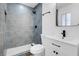 Updated bathroom with gray tile and modern vanity at 2028 Hassell Ave, North Las Vegas, NV 89032