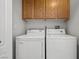 Laundry area with washer, dryer, and wood cabinets at 3540 Cactus Shadow St # 201, Las Vegas, NV 89129