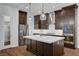 Modern kitchen featuring stainless steel appliances, dark cabinets, an island, and decorative pendant lighting at 395 Nine Mile Creek Dr, Las Vegas, NV 89138