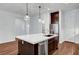 Open kitchen featuring an island with seating, dark cabinets, and stainless steel appliances at 395 Nine Mile Creek Dr, Las Vegas, NV 89138