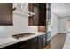 Well-equipped kitchen with stainless steel range hood, modern appliances, subway tile backsplash and wood floors at 395 Nine Mile Creek Dr, Las Vegas, NV 89138