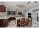 Island kitchen with dark wood cabinets, granite counters, and stainless steel appliances at 4929 Shady Rim Ct, Las Vegas, NV 89131