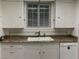 Kitchen featuring a double basin sink, white cabinets and backsplash at 509 5Th St, Boulder City, NV 89005