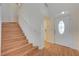 Bright entryway with wood-look floors, staircase, and a white door with a glass oval at 5648 Ancient Agora St, North Las Vegas, NV 89031