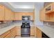 Kitchen with light wood cabinets, gas range and stainless steel appliances at 5648 Ancient Agora St, North Las Vegas, NV 89031