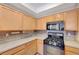 Kitchen with light wood cabinets, gas range and stainless steel appliances at 5648 Ancient Agora St, North Las Vegas, NV 89031