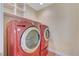 Laundry room with red washer and dryer, and shelving at 5648 Ancient Agora St, North Las Vegas, NV 89031