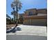 Two story tan home with a large two car garage and beautiful desert landscaping at 5805 Cabo San Lucas Ave, Las Vegas, NV 89131