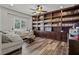 Comfortable living room with a light colored sectional couch, wood floors, and custom bookshelves at 5805 Cabo San Lucas Ave, Las Vegas, NV 89131