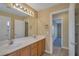 Bright bathroom features double sinks with neutral-toned cabinets, a large mirror, and access to another room at 5915 Poplar Tree St, Las Vegas, NV 89148