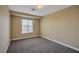 This neutral-painted bedroom features carpet floors and a large window for natural light at 5915 Poplar Tree St, Las Vegas, NV 89148