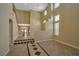 Bright and spacious living room with high ceilings, tile flooring and staircase access to second floor at 5915 Poplar Tree St, Las Vegas, NV 89148