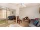 Bedroom with gray couches, wooden chair, and ceiling fan at 6781 Southgate St, Pahrump, NV 89061