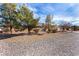 Landscaped yard with gravel driveway and mature trees at 6781 Southgate St, Pahrump, NV 89061