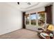 Relaxing bedroom with large windows, carpeting, and a comfortable armchair at 993 Starlight Terrace Way, Mesquite, NV 89034