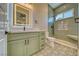 Bathroom featuring a green vanity, a lighted mirror, and a tiled shower with a built-in seat at 1131 Blackhorn St, Pahrump, NV 89048