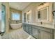 Elegant bathroom featuring a soaking tub, dual vanity, and decorative lighting at 1131 Blackhorn St, Pahrump, NV 89048