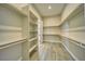 Walk-in closet with custom shelving and wood-look tile flooring at 1131 Blackhorn St, Pahrump, NV 89048