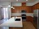 Modern kitchen with island, stainless steel appliances, and wood cabinets at 1706 Pondering Ave, North Las Vegas, NV 89031