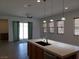 Modern kitchen with island, white countertops and wood cabinets at 1706 Pondering Ave, North Las Vegas, NV 89031