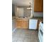 A closer shot of kitchen features wooden cabinets, tile countertops, and white appliances at 3025 Sunrise Bay Ave, North Las Vegas, NV 89031