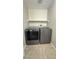 Functional laundry room featuring modern washer and dryer, stylish cabinets, and easy-to-clean tiled flooring at 3025 Sunrise Bay Ave, North Las Vegas, NV 89031