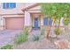 Landscaped front yard with gray front door and porch at 4025 Redwood Glen Ct, Las Vegas, NV 89141