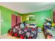 Cozy bedroom with green walls featuring a large mirror and a floral bedspread at 4214 Bay Cir, Las Vegas, NV 89122