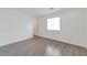 This bedroom features gray wood floors, a bright window, and white walls at 4929 Morning Falls Ave, Las Vegas, NV 89131