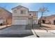 Two-story home featuring a two-car garage and low maintenance gravel landscaping at 4929 Morning Falls Ave, Las Vegas, NV 89131