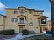 Tan three-story townhome with balcony and landscaping at 5960 Palmilla St # 3, North Las Vegas, NV 89031