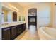 Double vanity bathroom with soaking tub and view of bedroom at 7260 Fruitful Harvest Ave, Las Vegas, NV 89131