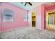 Bright bedroom with pink walls, ceiling fan, and walk-in closet at 7260 Fruitful Harvest Ave, Las Vegas, NV 89131