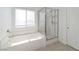 Bright bathroom with a soaking tub, a glass-enclosed shower, and a large window at 9247 Tulip Trestle Ave, Las Vegas, NV 89148