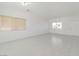 Large living room featuring ceramic tile flooring and natural light from two windows at 9247 Tulip Trestle Ave, Las Vegas, NV 89148