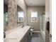 Shared bathroom with double sinks, a shower/tub combo, and geometric tile at 107 Reflection Cove Dr, Henderson, NV 89011